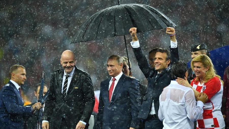 Para pemimpin dunia tersebut diguyur hujan di atas podium usai laga final Piala Dunia.