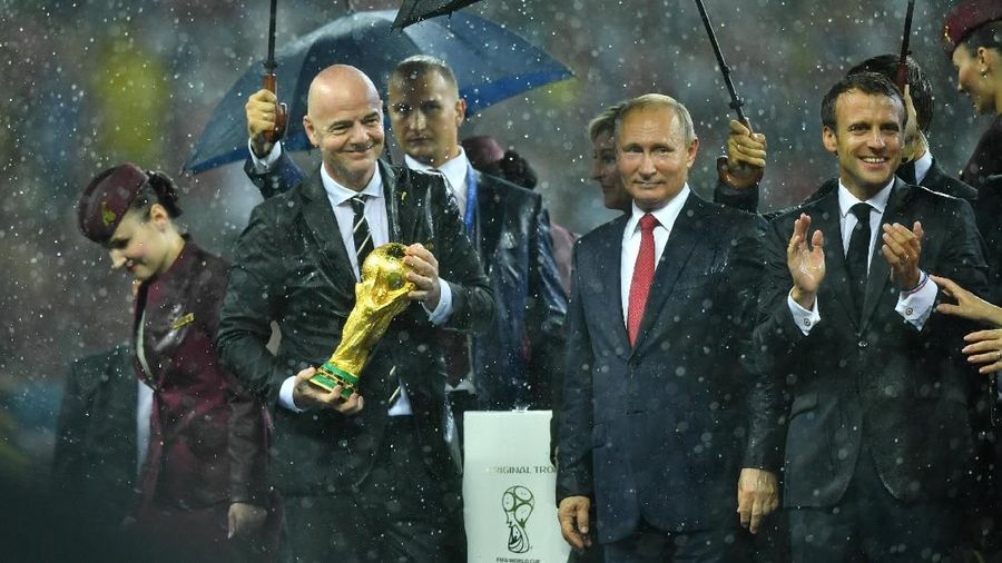 Para pemimpin dunia tersebut diguyur hujan di atas podium usai laga final Piala Dunia.