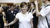 Salah satu personel Pussy Riot yang ikut menyusup ke lapangan di laga final Piala Dunia 2018 Minggu (15/7), Olga Pakhtusova, digelandang polisi ke gedung pengadilan Rusia. (REUTERS/Sergei Karpukhin)
