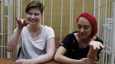 Anggota Pussy Riot, Olga Pakhtusova (kiri) dan Olga Kurachyova, hadir dalam persidangan di Rusia. Band punk-rock asal Rusia itu dikenal paling vokal atas isu-isu feminisme dan kaum marginal. (REUTERS/Sergei Karpukhin)
