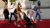 Istri Olivier Giroud (kanan), Jennifer Giroud beserta dua anaknya, Jade dan Evan, serta sang mertua ikut menyaksikan sang ayah diterima Presiden Prancis, Emmanuel Macron, di Elysee Palace. (REUTERS/Philippe Wojazer)