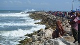 Warga memadati perairan untuk melihat proses evakuasi perahu nelayan karam diterjang ombak di Plawangan Puger, Jember, Jawa Timur, Kamis (19/7). (ANTARA FOTO/Seno)
