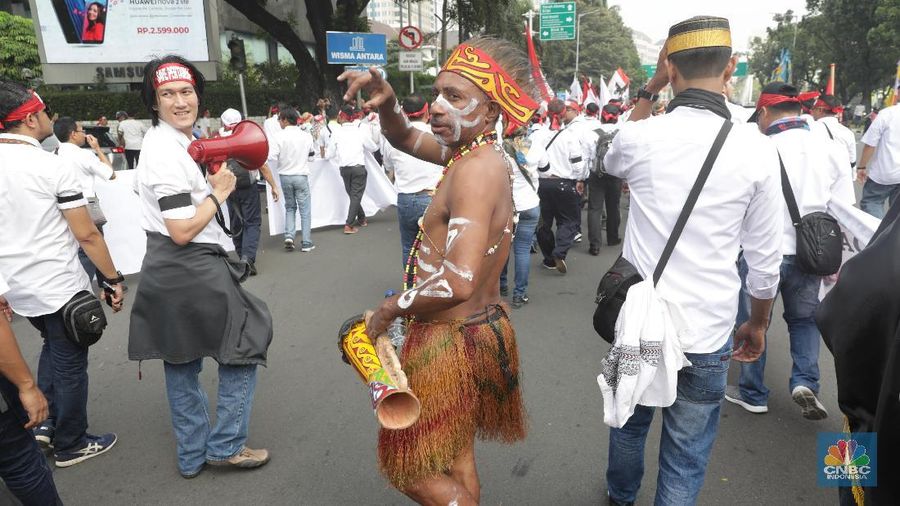 Dengan pakaian adat khas Papua mereka melakukan long march dan berorasi di depan Gedung kementerian BUMN.
