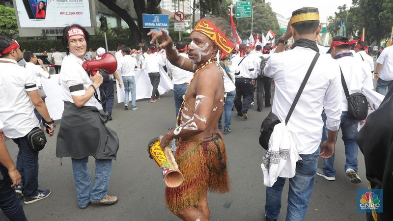 Dengan pakaian adat khas Papua mereka melakukan long march dan berorasi di depan Gedung kementerian BUMN.