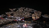 Seorang pria India sedang menunggu jenazah berhasil dikremasikan dan akan disebar di Sungai Gangga, sungai yang dianggap suci oleh umat Hindu di India. (AFP PHOTO / CHANDAN KHANNA)
