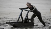 Peserta lomba kereta luncur di atas lumpur dalam ajang Olympiade Lumpur. REUTERS/Morris Mac Matzen