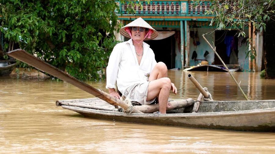 A man rows past his flooded house after heavy rainfall caused by tropical storm Son Tinh in Ninh Binh province, Vietnam, July 22, 2018. REUTERS/Kham
