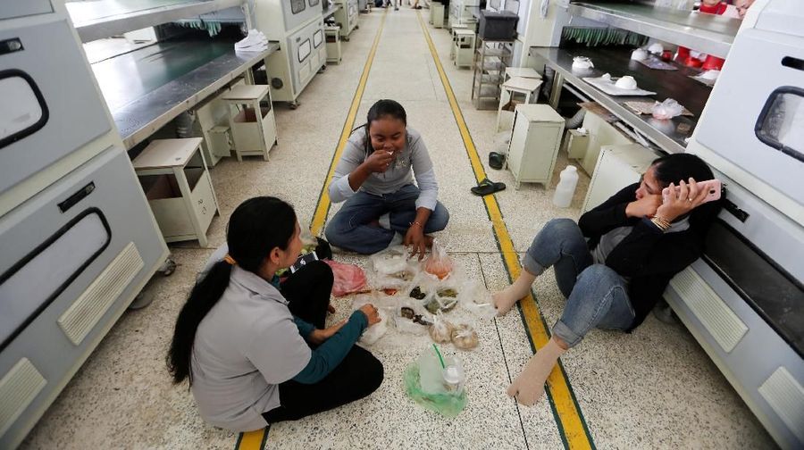 Women seat on the floor during their lunch break at Complete Honour Footwear Industrial, a footwear factory owned by a Taiwan company, in Kampong Speu, Cambodia, July 5, 2018. REUTERS/Ann Wang    SEARCH 