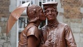 Ada pula yang melumuri diri mereka dengan cokelat, sehingga seperti patung cokelat. (REUTERS/Yves Herman)