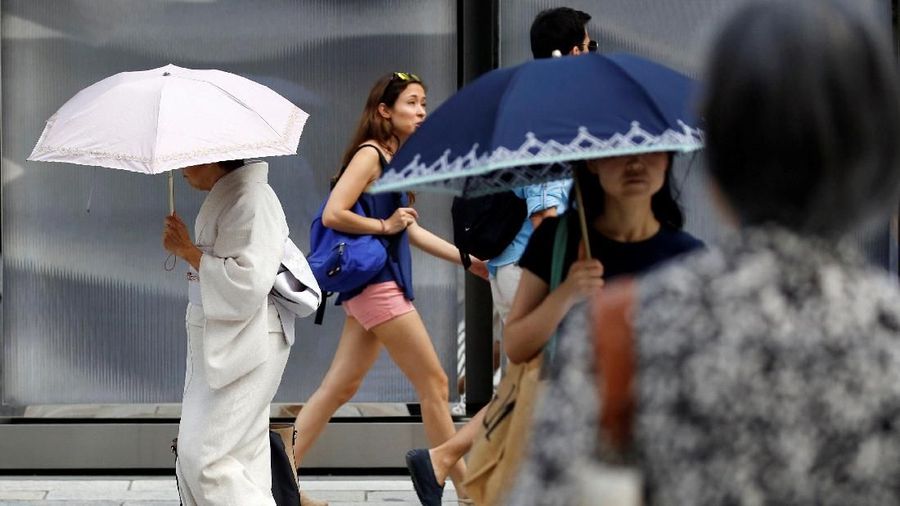 A kimono-clad woman using a sun umbrella walks on a street during a heatwave in Tokyo, Japan July 23, 2018.  REUTERS/Issei Kato