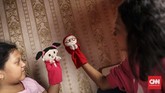 Rara berlatih dengan Sasha memainkan boneka puppet. Bermain layaknya seorang dalang, boneka puppet dimainkan menggunakan tangan dan saling mengborol satu sama lain, mengeluarkan suara dengan bibir yang masih bergerak. (CNN Indonesia/ Hesti Rika)