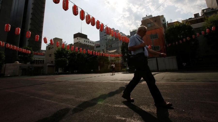 Passersby walk under the light of the sun and paper lanterns decoration for a Bon Odori festival, a Japanese traditional summer dance festival, during a heatwave in Tokyo, Japan July 23, 2018. REUTERS/Issei Kato