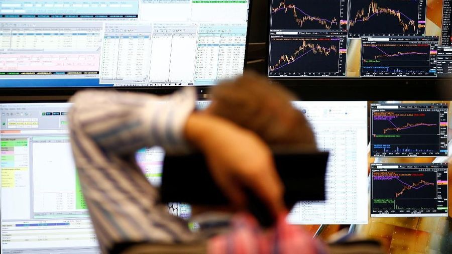 FILE PHOTO: A trader sits in front of the computer screens at his desk at the Frankfurt stock exchange, Germany, June 29, 2015.  REUTERS/Ralph Orlowski/File Photo