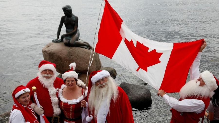 People dressed as Santa Claus, meet at the Little Mermaid statue, as they take part in the World Santa Claus Congress, an annual event held every summer in Copenhagen, Denmark, July 23, 2018.  REUTERS/Andrew Kelly