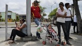 Warga menunggu transportasi di Barquisimeto, Venezuela. Sebagian warga memilih berjalan kaki dan tak menggunakan transportasi karena bingung bagaimana harus membayar. (AFP PHOTO / Luis ROBAYO)