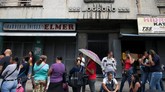 Warga Venezuela mengantri di depan mesin ATM. Negara ini telah kehilangan nilai mata uangnya lebih dari 99 persen. (REUTERS/Adriana Loureiro)