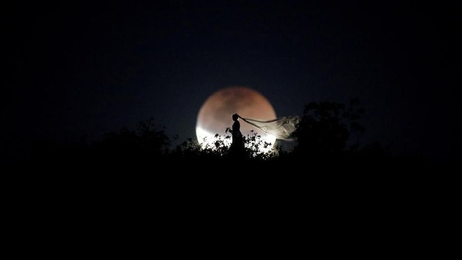A bride poses for photo during a total lunar eclipse from in Brasilia, Brazil, July 27, 2018. REUTERS/Ueslei Marcelino      TPX IMAGES OF THE DAY