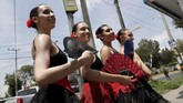Lagu-lagu untuk mengiringi tarian itu dikumandangkan lewat pengeras suara yang disambungkan ke iPod. Mereka berebutan menguar dengan suara lengkingan klakson, deru mobil maupun teriakan pengendara lain yang sedang tidak berhenti. (REUTERS/Henry Romero)