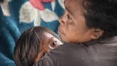Seorang perempuan mengendong anaknya di tenda perawatan pascagempa di Desa Sembalun Bumbung, Kecamatan Sembalun, Selong, Lombok Timur, NTB, Minggu (29/7). (ANTARA FOTO/Ahmad Subaidi)