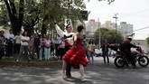 Tak hanya pengguna kendaraan, mereka yang sedang berjalan dan tak sengaja lewat situ pun terhibur. Bahkan ada yang berlari pulang dan kembali mengajak dua cucu perempuannya untuk menonton pertunjukan gratis itu. (REUTERS/Henry Romero)