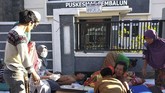 Warga korhaan gempa mendapatkan perawatan di luar Puskesmas Sembalun Selong, Lombok Timur, NTB, Minggu (29/7). (ANTARA FOTO/Zakir)