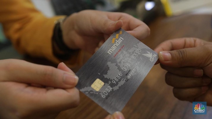 GPN Bank Mandiri Nasabah menukar kartu ATM visa menjadi GPN Plaza Mandiri, Jakarta, Senin (30/7). Bank Indonesia (BI) dan perbankan menggelar kampanye Gerbang Pembayaran Nasional (GPN). Kegiatan penukaran kartu pada 30 Juli-3 Agustus 2018. Pekan penukaran kartu berlogo GPN merupakan tindak lanjut acara peluncuran bersama kartu berlogo GPN di Jakarta pada 3 Mei 2018. Kartu berlogo GPN diharapkan untuk memudahkan masyarakat untuk melakukan transaksi pada seluruh kanal pembayaran (EDC) yang tersedia, sehingga akan meningkatkan efisiensi waktu dan biaya. (CNBC Indonesia/Muhammad Sabki)