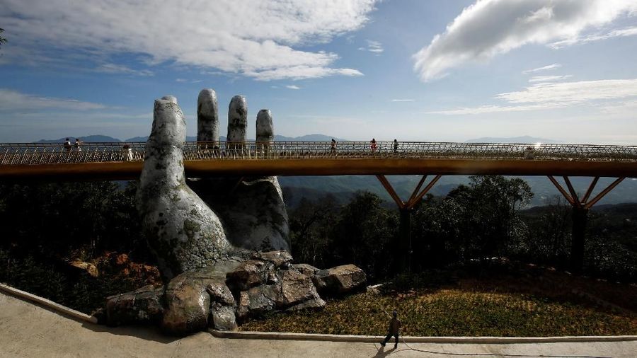 Sepasang tangan raksasa yang diukir dari batu sedang menahan Jembatan Emas menjadi daya tarik wisatawan.