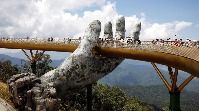 Sepasang tangan raksasa yang diukir dari batu sedang menahan Jembatan Emas menjadi daya tarik wisatawan.
