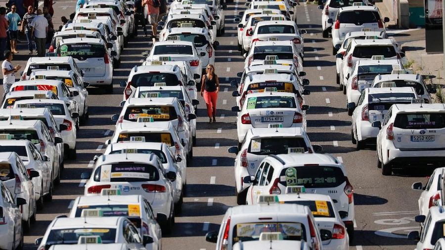 Taxis block a section of the main avenue Paseo de la Castellana during an indefinite strike against what they say is unfair competition from ride-hailing and car-sharing services such as Uber and Cabify, in Madrid, Spain, July 31, 2018. REUTERS/Paul Hanna