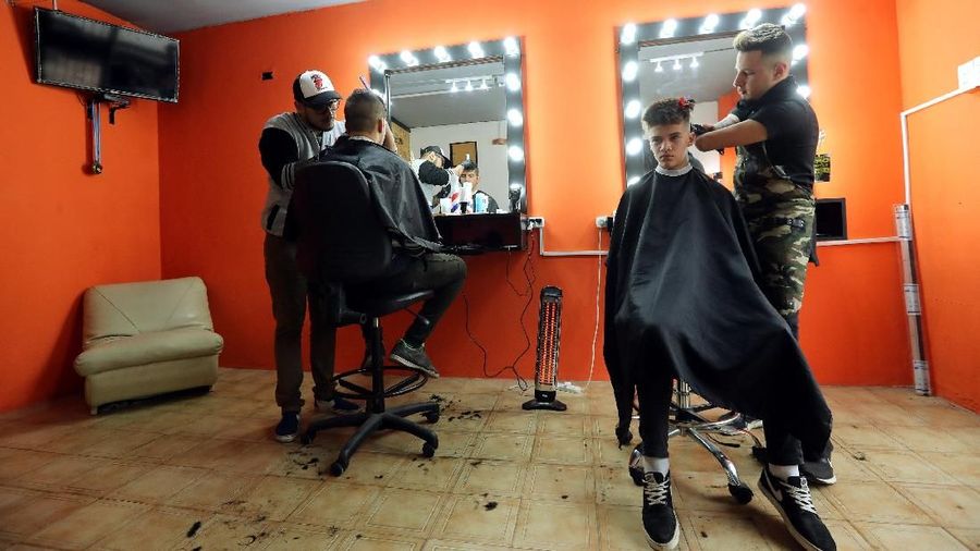 Barber Gabriel Heredia, who was born with no forearms or hands, cuts a customer's hair at his shop in Buenos Aires, Argentina, August 3, 2018. REUTERS/Marcos Brindicci