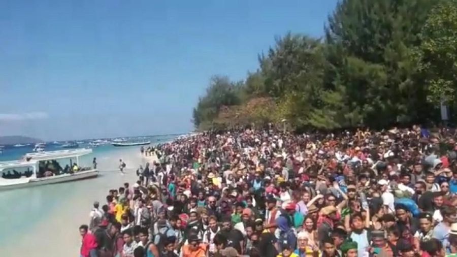 Orang-orang berkerumun di pantai saat mereka berusaha meninggalkan Kepulauan Gili.