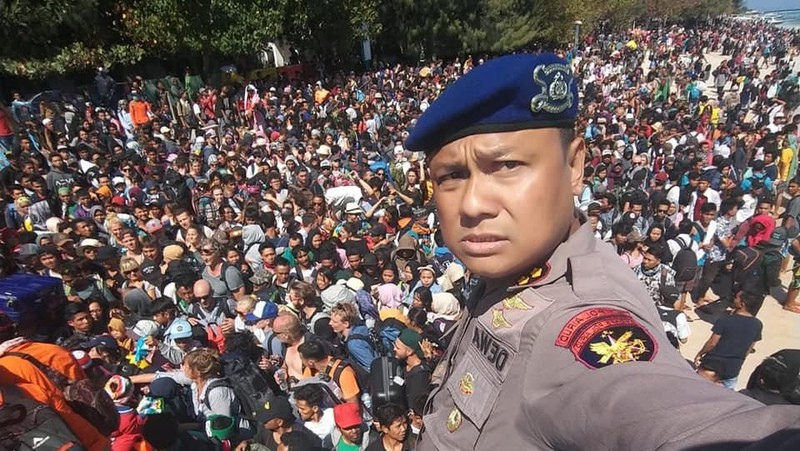 Orang-orang berkerumun di pantai saat mereka berusaha meninggalkan Kepulauan Gili.