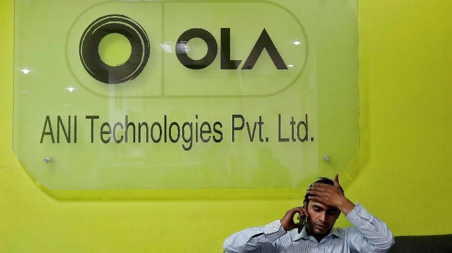 FILE PHOTO: An employee speaks over his phone as he sits at the front desk inside the office of Ola cab service in Gurugram, previously known as Gurgaon, on the outskirts of New Delhi, India, April 20, 2016. REUTERS/Anindito Mukherjee/File Photo