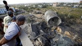 Warga Palestina memeriksa kerusakan akibat serangan Israel di Al-Mughraqa, pinggiran Kota Gaza. (REUTERS/Mohammed Salem)