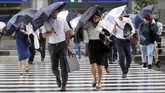 Para pejalan kaki di Tokyo, Jepang, yang hanya berlindung di bawah payung kesulitan menyebrang ketika hujan deras dan angin topan Shanshan terjadi. (REUTERS/Toru Hanai)