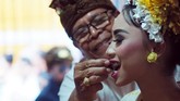 Setelah dikikir, mereka diminta menggigit beberapa benda yang melambangkan enam rasa, sebagai pertanda mereka telah siap mencecap semua rasa di dunia, lalu memegang koin kuno. (Mahendra Moonstar - Anadolu Agency)
