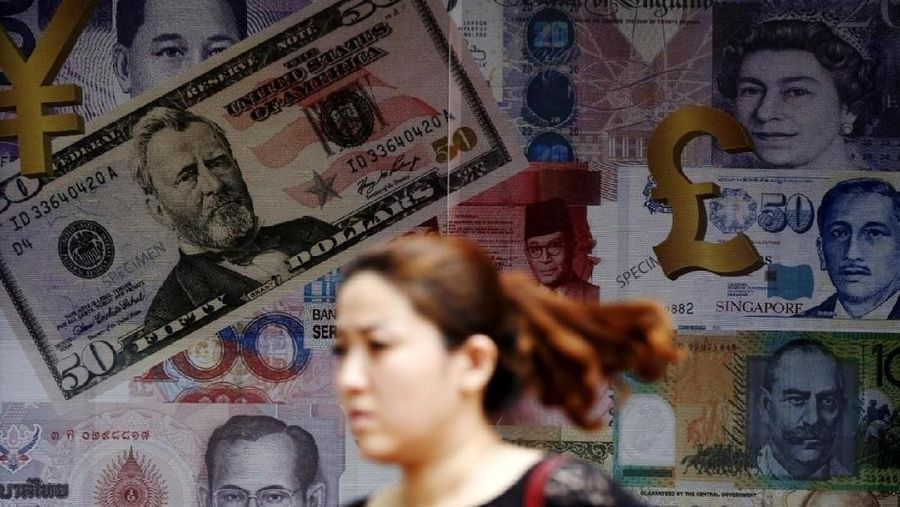 A woman walks past a money exchange shop in Kuala Lumpur, Malaysia, August 25, 2015. REUTERS/Olivia Harris.
