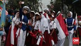 Sejumlah anak sekolah dasar berswadaya foto sambil menunggu kirab obor Asian Games di kawasan jalan Mangga Besar, Jakarta. (CNN Indonesia/Andry Novelino)