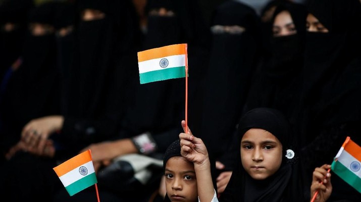 Girls hold the Indian national flags as they attend a flag hoisting ceremony during India's Independence Day celebrations in Ahmedabad, India August 15, 2018. REUTERS/Amit Dave