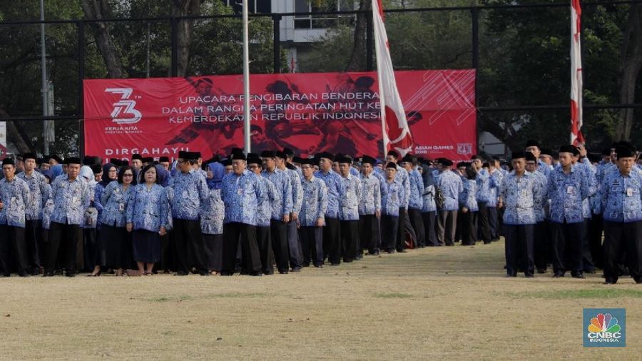 Pegawai PNS tiba menghadiri Upacara Kemerdekaan RI ke-73 di Lapangan Banteng, Jakarta, Jumat (17/8). Upacara diikuti pejabat Pemerintah Provinsi DKI Jakarta dan ratusan pegawai negeri sipil (PNS) DKI Jakarta yang berbaris memanjang dengan mengenakan batik Korpri biru dan celana hitam. Bagi peserta upacara pria mengenakan peci hitam. Tak ketinggalan pelajar, petugas pemadam kebakaran, anggota Kepolisian RI (Polri), Tentara Nasional Indonesia (TNI) baik itu angkatan darat, laut, dan udara ikut dalam barisan upacara.(CNBC Indonesia/Muhammad Sabki)