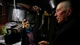 Tamara dan Yuri Baikov mendengarkan radio di dalam pondok mereka yang terletak di hutan dekat desa Yukhovichi, Belarusia. (REUTERS/Vasily Fedosenko)