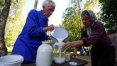 Tamara dan Yuri Baikov menuangkan susu kambing di pertanian kecil mereka. Suami dan istri ini telah hidup lebih dari seperempat abad dalam kehidupan primitif.(REUTERS/Vasily Fedosenko)