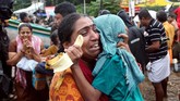 Seorang wanita menangis sambil menggendong putranya saat dievakuasi di Aluva, Kerala, India.