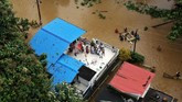 Orang-orang menunggu bantuan di atap-atap rumah mereka di Kerala, India.