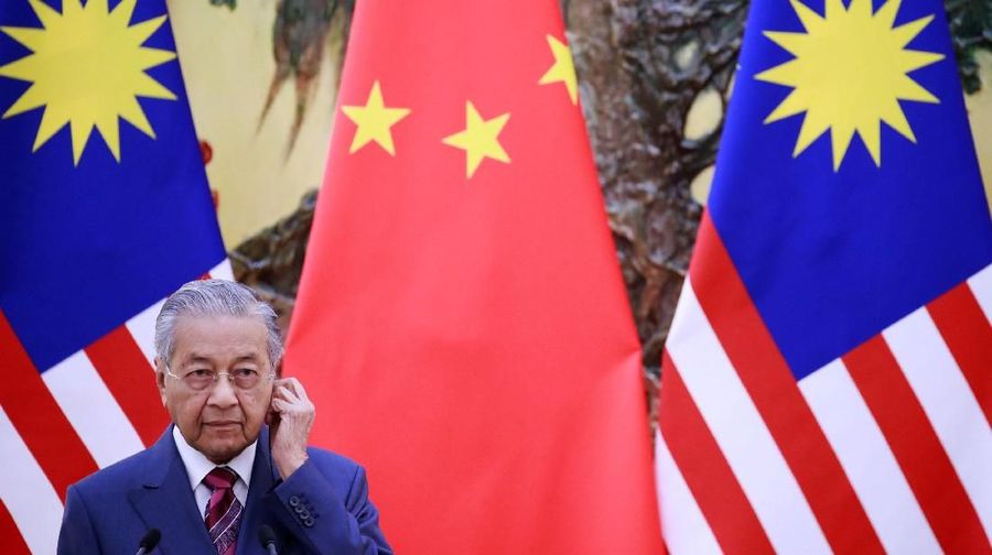 Malaysia's Prime Minister Mahathir Mohamad adjusts his earphones during a news conference with China's Premier Li Keqiang (not pictured) at the Great Hall of the People in Beijing, China, August, 20, 2018. How Hwee Young/Pool via REUTERS