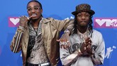 Duo Quavo dan Offset of the Migos bergaya berani dengan gaya warna busana dan celana panjang perak yang tak biasa. (REUTERS/Andrew Kelly)