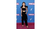 Millie Bobby Brown tampil dengan elegan. Jumpsuit hitamnya menggambarkan gaya dewasa dan sedikit seksi dengan paduan crop top hitam dan aksen tali yang menyatukan detail di bahunya. (REUTERS/Andrew Kelly)