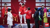 Presiden Joko Widodo mengalungkan medali emas kepada lifter Indonesia Eko Yuli Irawan. Eko Yuli mengalahkan Vietnam Van Vinh Trinh dan lifter Uzbekistan Adkhamjon Ergashev. (CNNIndonesia/Safir Makki)
