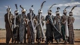 Sekelompok pria dari suku Fulani dari Nigeria menampilkan tarian tradisional untuk menyambut kehadiran PBB di bandara Baradi, Nigeria. PBB mendatangi daerah itu untuk memahami kebutuhan kelompok-kelompok di sana yang terpengaruh perubahan iklim. (AFP/Luis Tato)