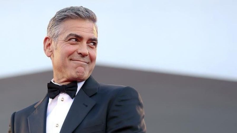 U.S. actor George Clooney smiles as he arrives on the red carpet for the premiere of